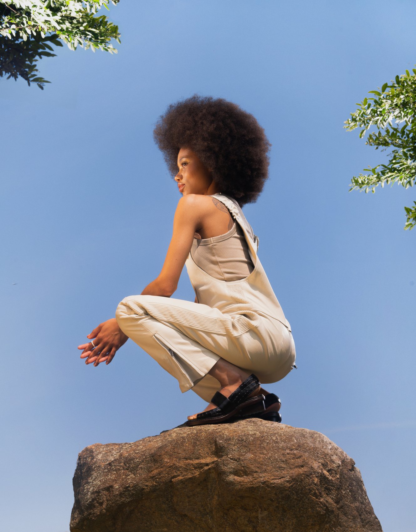 Future Society campaign — model crouched on a boulder against the sky