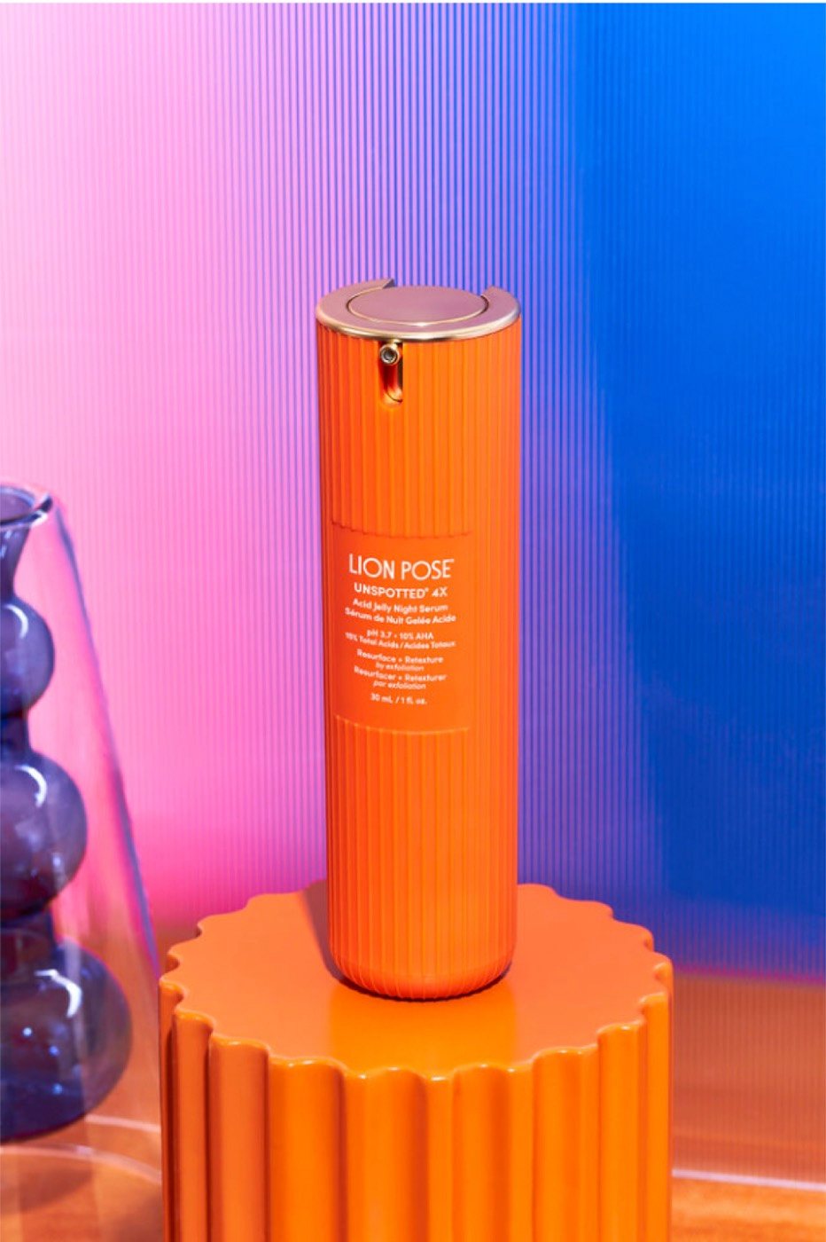 Lion Pose Unspotted serum on an orange pedestal